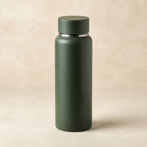 Matte forest-green Waypoint Bottle stainless vacuum travel bottle on a warm ivory surface
